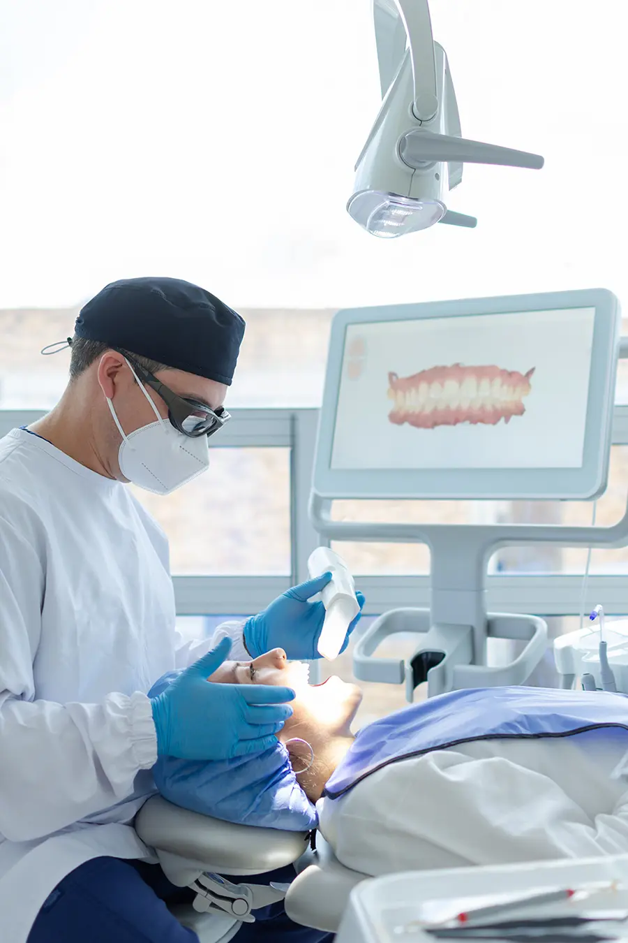 Dentist scanning a patient’s teeth with an intraoral scanner in a dental clinic