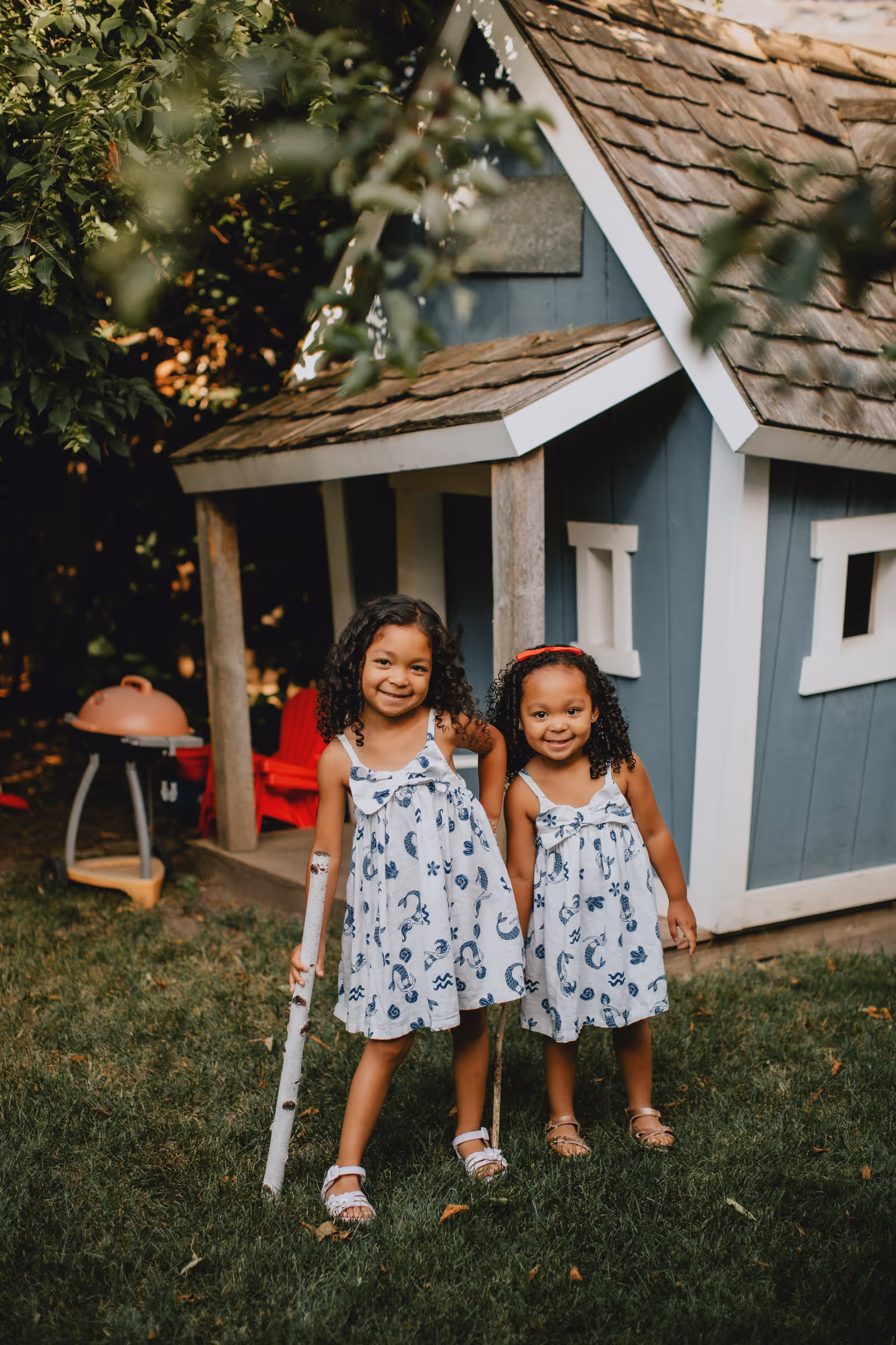 Two little girls standing in front of a house.